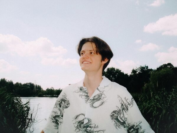 A young adult enjoying a sunny day by a river in Łódź, Poland.